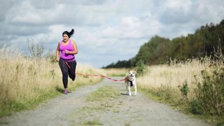 Woman running with her dog on a loose leash