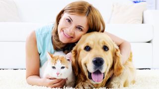 Woman hugging dog and cat